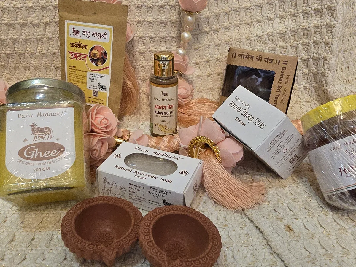 Ghee jar, soap, dhoop sticks and clay diyas among pink flowers